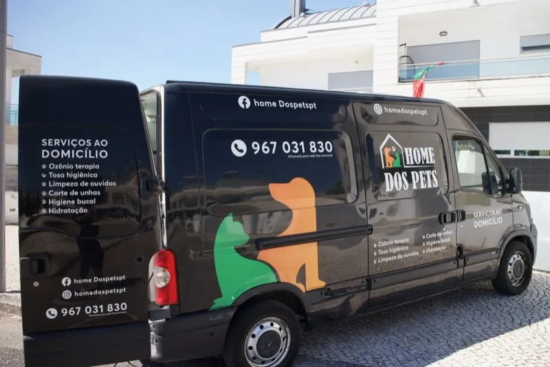 Carrinha preta da Home dos Pets com a lista de serviços ao domicílio